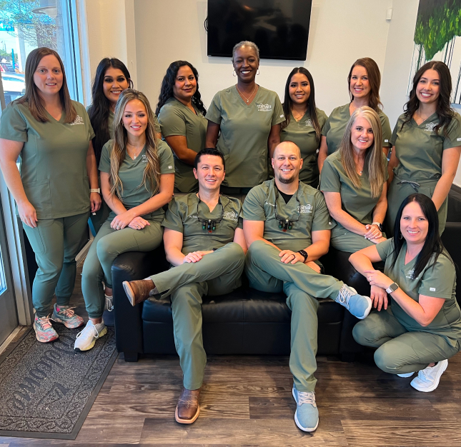 Stonehaven Dental & Orthodontics team posing together in office wearing matching scrubs.